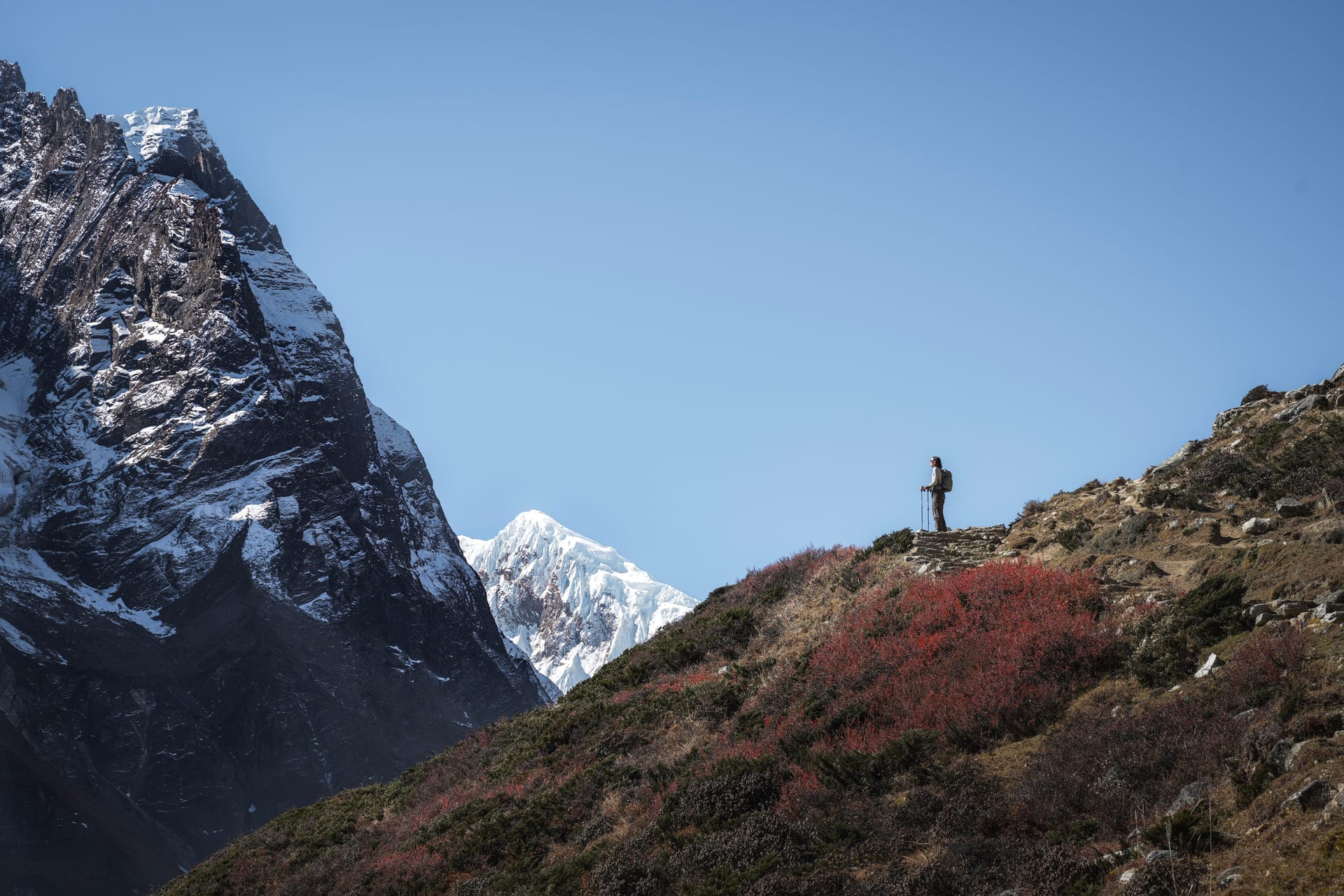 Reiziger kijkt naar berglandschap bij zonsondergang